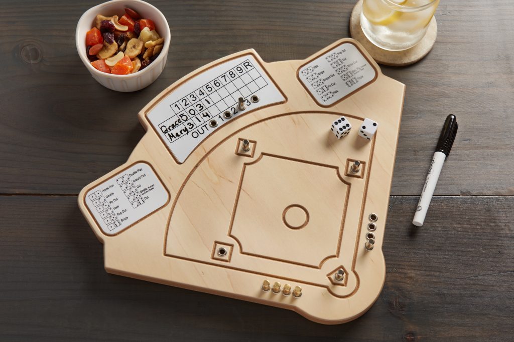 Across the Board wooden tabletop baseball game sits on a table with snacks
