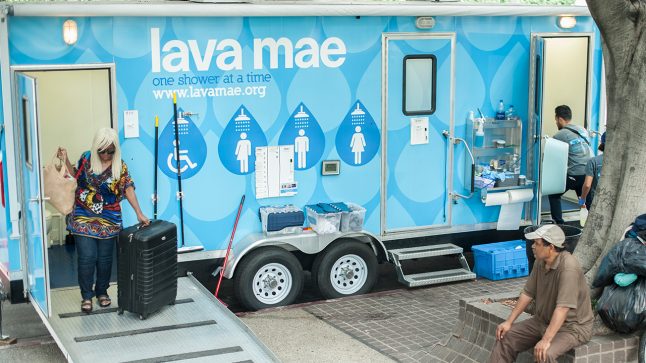 People are seen entering and exiting a Lava Mae portable shower bus.