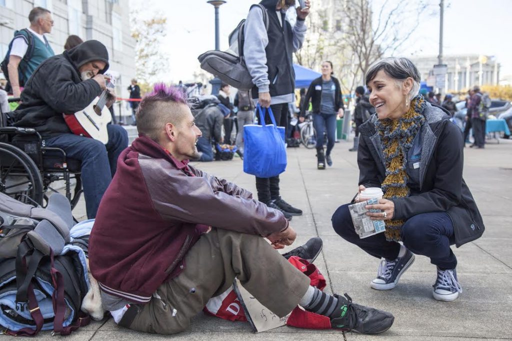 Lava Mae founder Doniece Sandoval chats with homeless man on the street