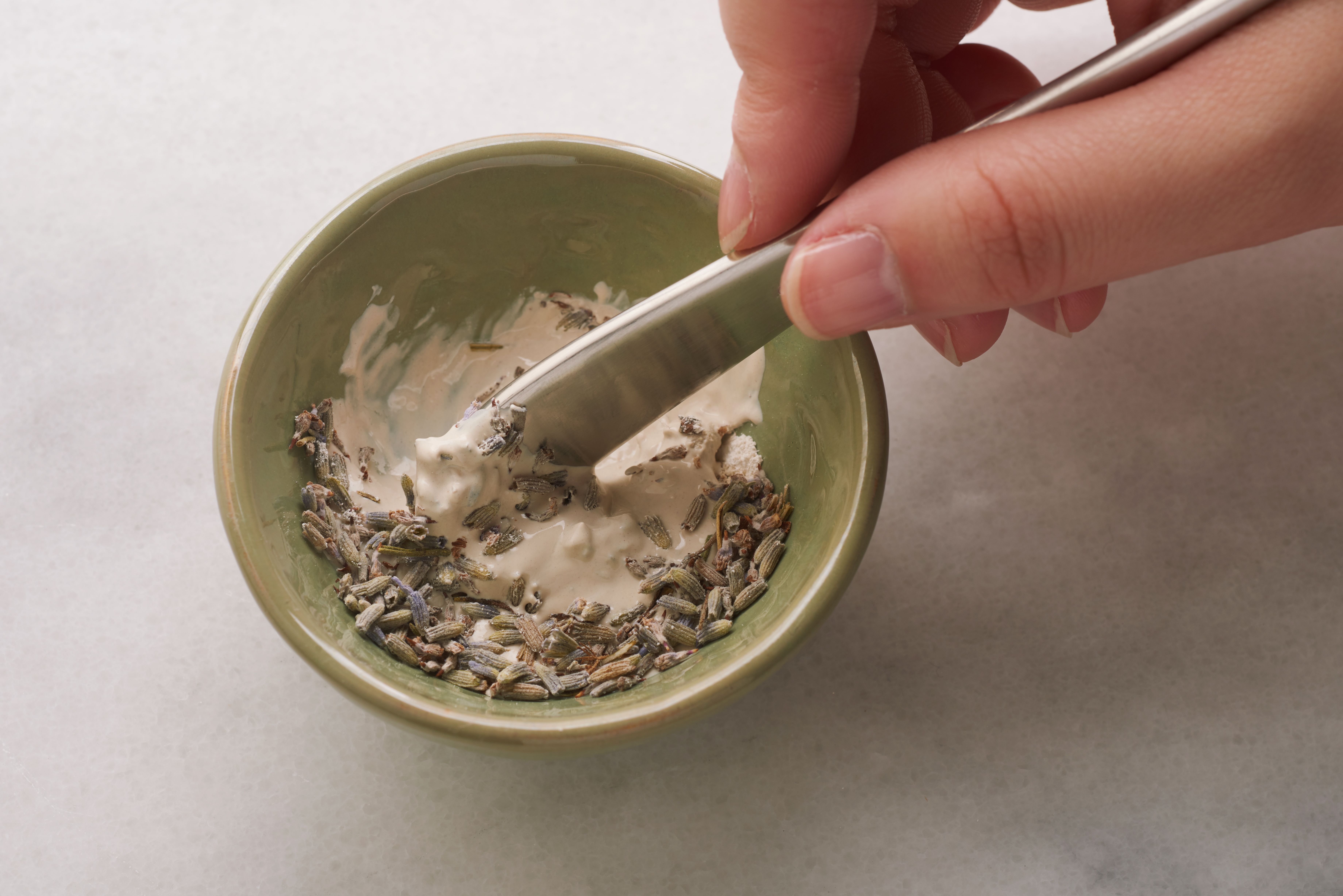 A woman is seen mixing together the ingredients for a DIY face mask from Oleum Vera
