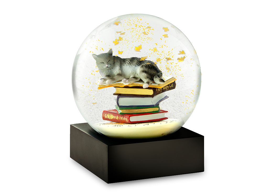 A sleepy cat lays on top of a pile of books surrounded by butterflies in this unique snow globe from CoolSnowGlobes