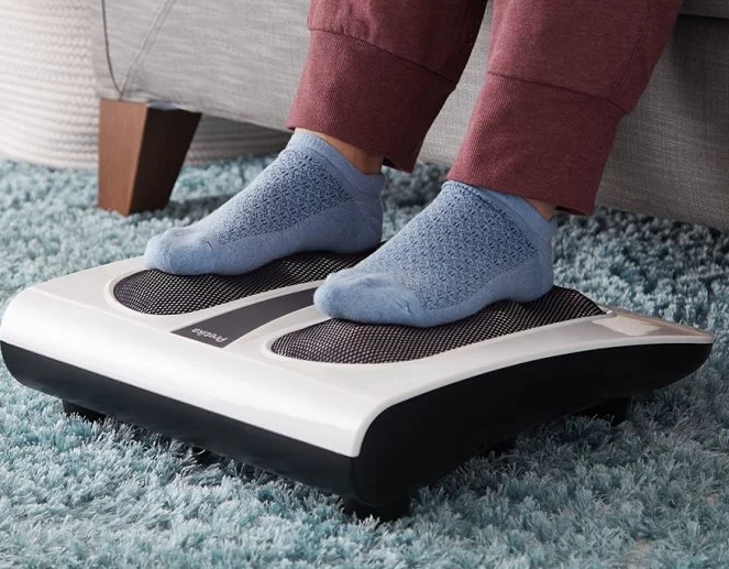 A person wearing blue socks is seen getting a thermal shiatsu foot massage with Pretika