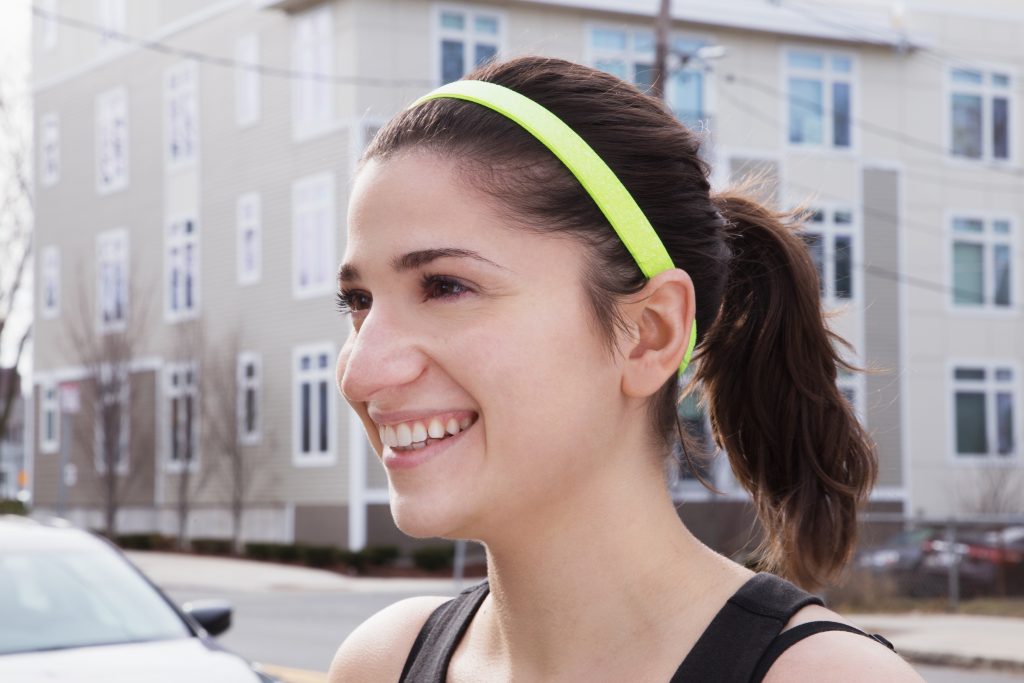 A girl is seen running wearing a sparkly neon wide no-slip headband from Sparkly Soul