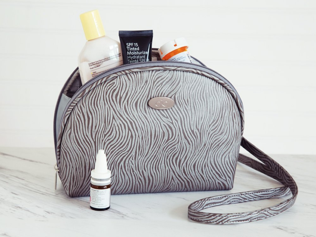 A zebra striped freezer pack crossbody toiletry bag from Cool-It Caddy sits on a counter