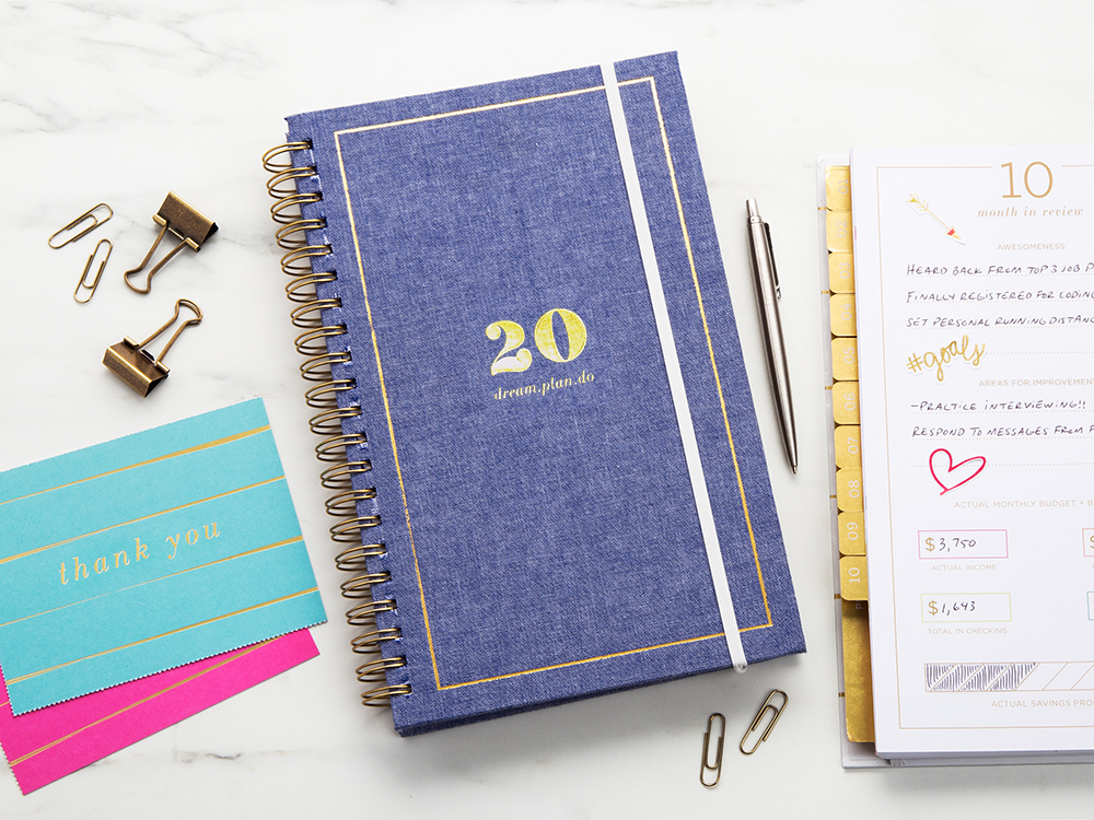 A 2020 inspirational planner from lake + loft is seen with thank you cards, paperclips and a pen