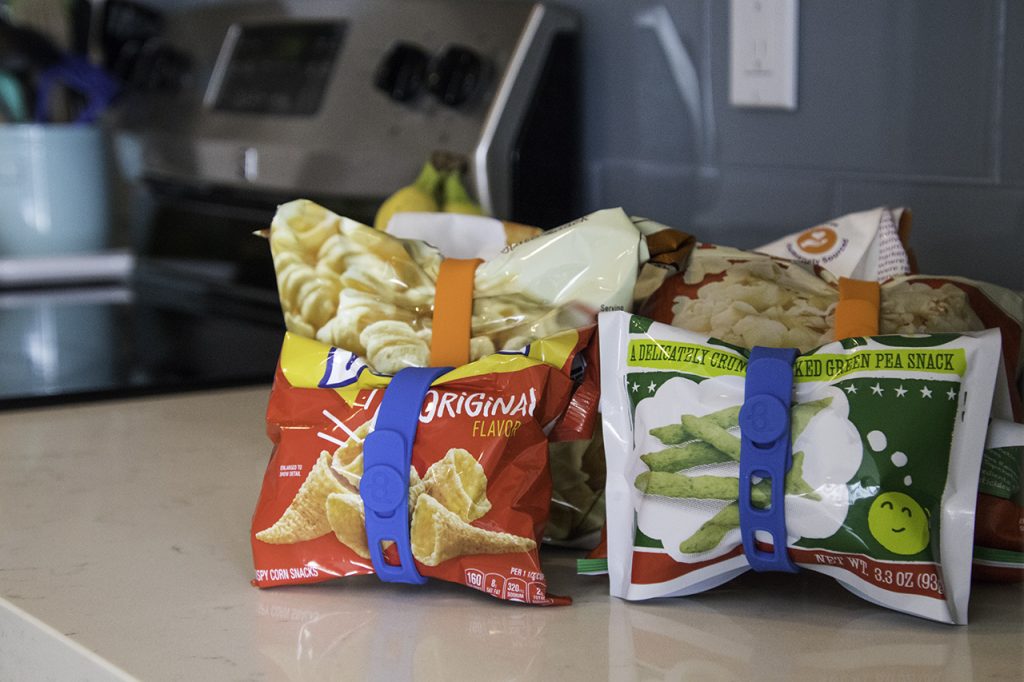 Bags of snacks are seen clipped closed using Packbands silicone organization bands